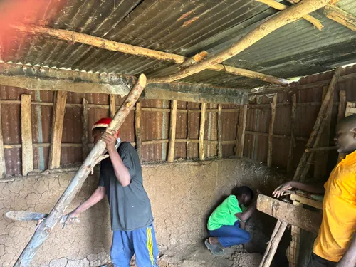 Community members building a mushroom hut together